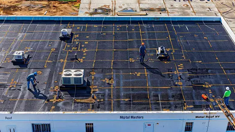 Metal roof master roofers doing work on a flat metal roof